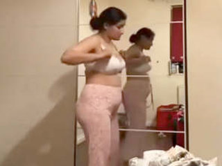 Pakistani milf strips down to a white bra and flashes her pantyless ass