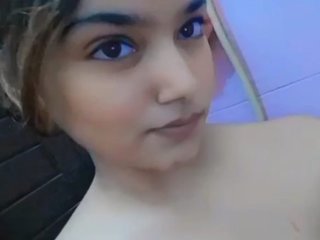 A stunning Indian woman elegantly bathes herself