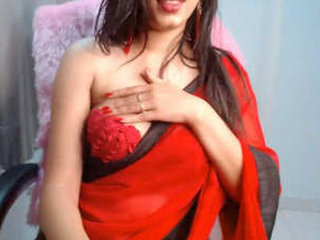 A stunning beauty in a red saree fondles her gorgeous breasts