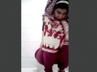 Watch as a girl shows off her pee in the bathroom
