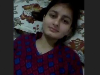 A woman in a suit masturbates by touching her breasts and vagina